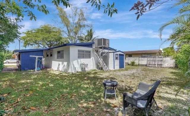 a backyard of a house with table and chairs
