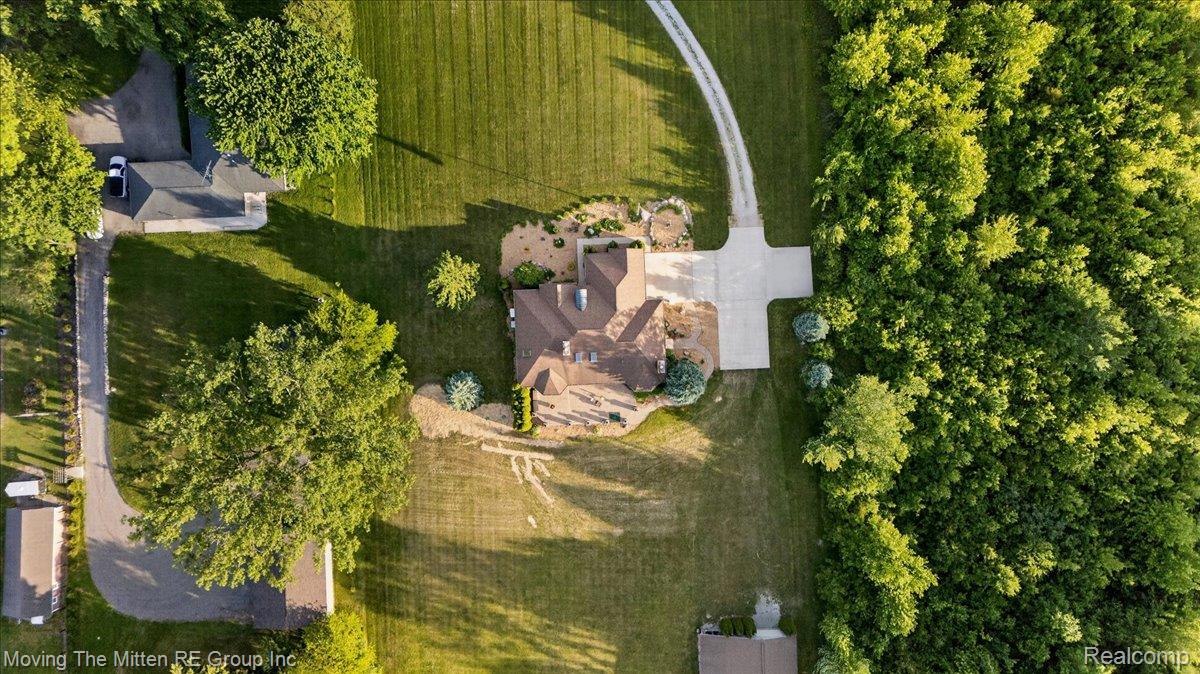 39750 Willow Road New Boston, MI 48164 - Photo 62 of 68 Aerial view showcasing a property with extensive manicured lawns, a winding driveway, and a natural tree line