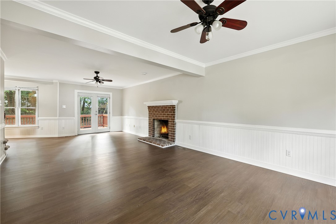 Unfurnished living room featuring ceiling fan, orn