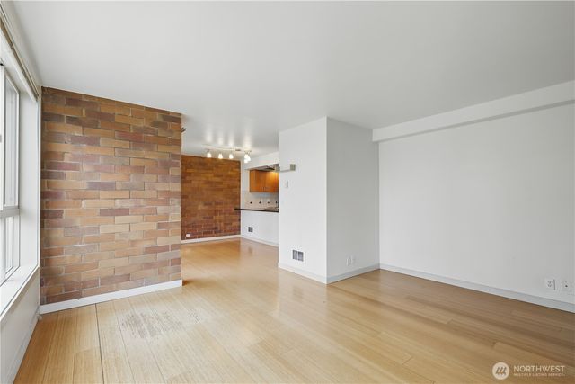 a view of empty room with wooden floor and entryway