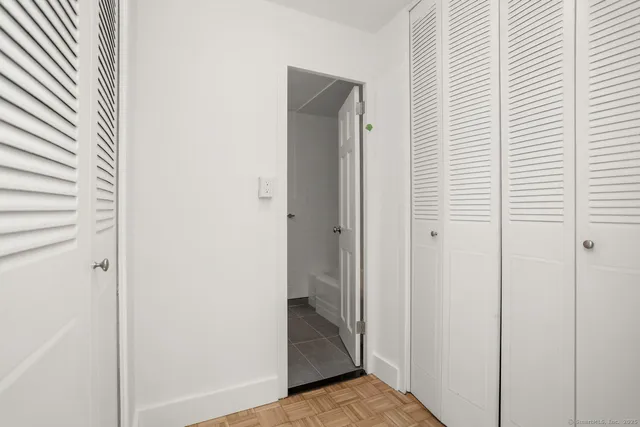 a view of a hallway with closet and bathroom
