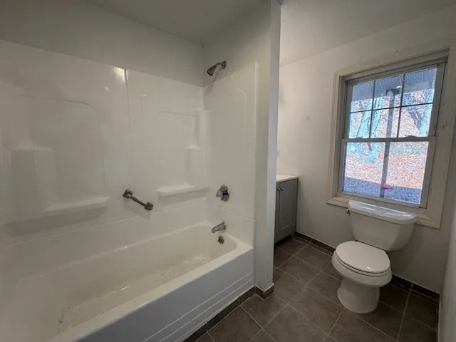 a bathroom with a bathtub toilet and window