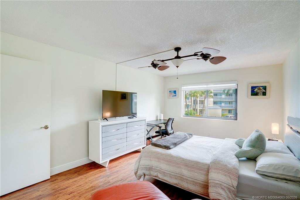10 Northeast Plantation Road, Unit 101 Jensen Beach, FL 34957 - Photo 41 of 53 a bedroom with a bed and wooden floor