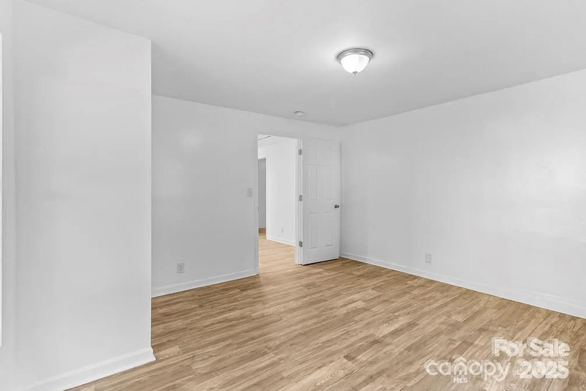 332 Mountain View Street Gastonia, NC 28052 - Photo 4 of 8 a view of an empty room with wooden floor