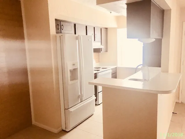 a kitchen with a refrigerator and a sink
