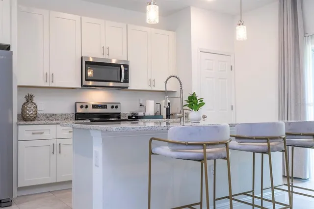 a kitchen with stainless steel appliances white cabinets a sink and a stove