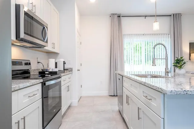 a kitchen with stainless steel appliances granite countertop a stove and a microwave