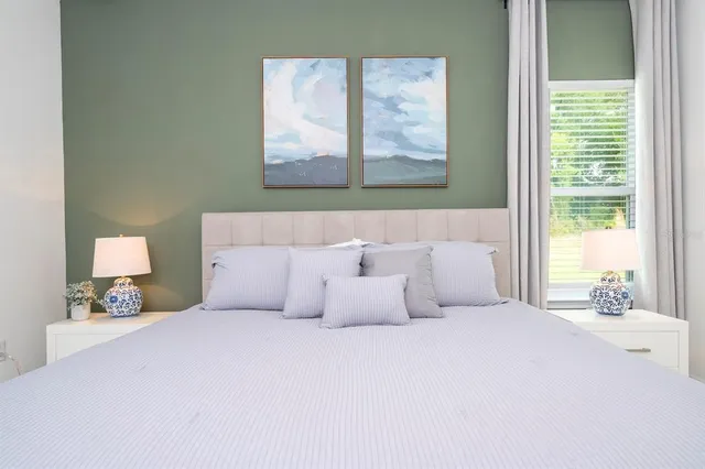 a bedroom with a bed and a chandelier fan