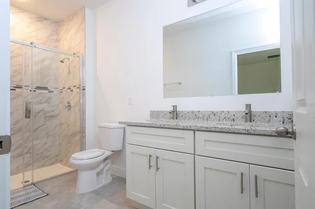 a bathroom with a granite countertop sink toilet and shower