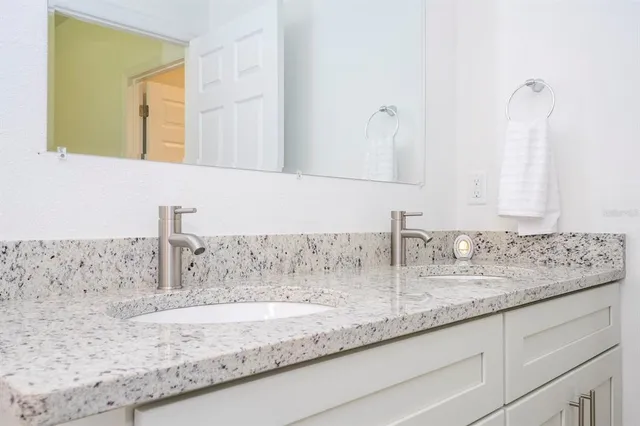 a spacious bathroom with a granite countertop toilet a sink and a mirror