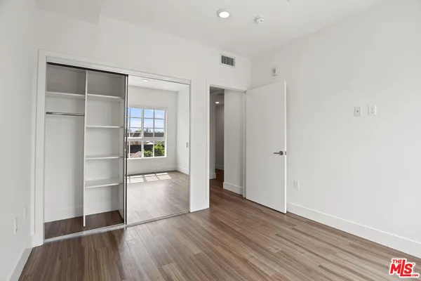 a view of a kitchen with wooden floor and a refrigerator