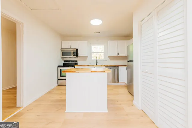 a kitchen with refrigerator cabinets and a sink