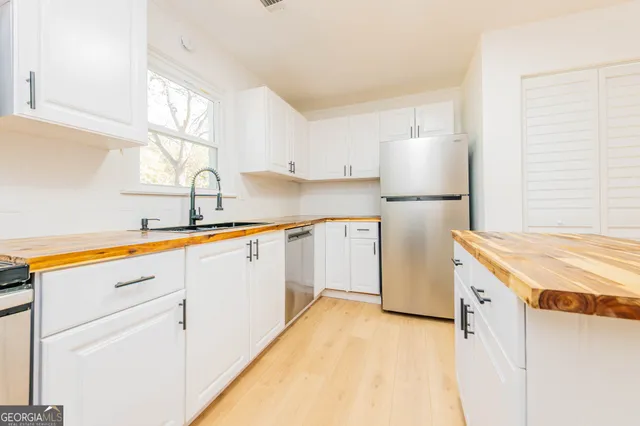 a kitchen with a sink a stove a refrigerator and a window