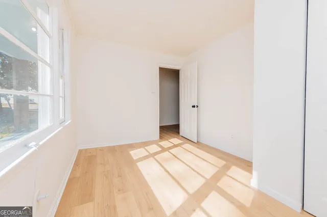 a view of a room with wooden floor and a window