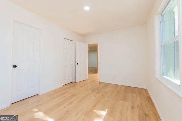 a view of empty room with wooden floor