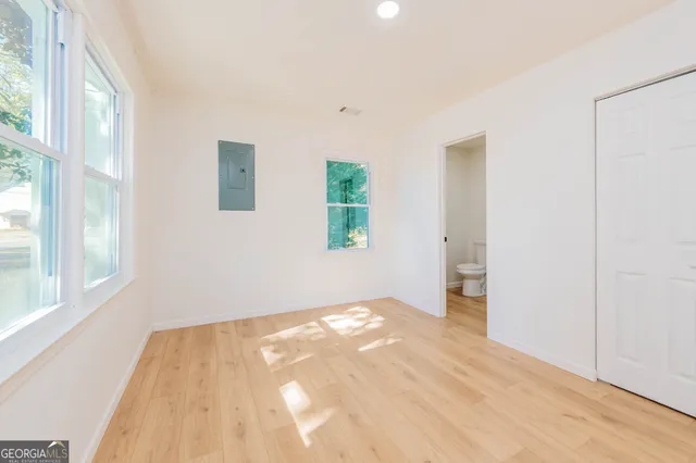 a view of a bedroom with wooden floor and windows