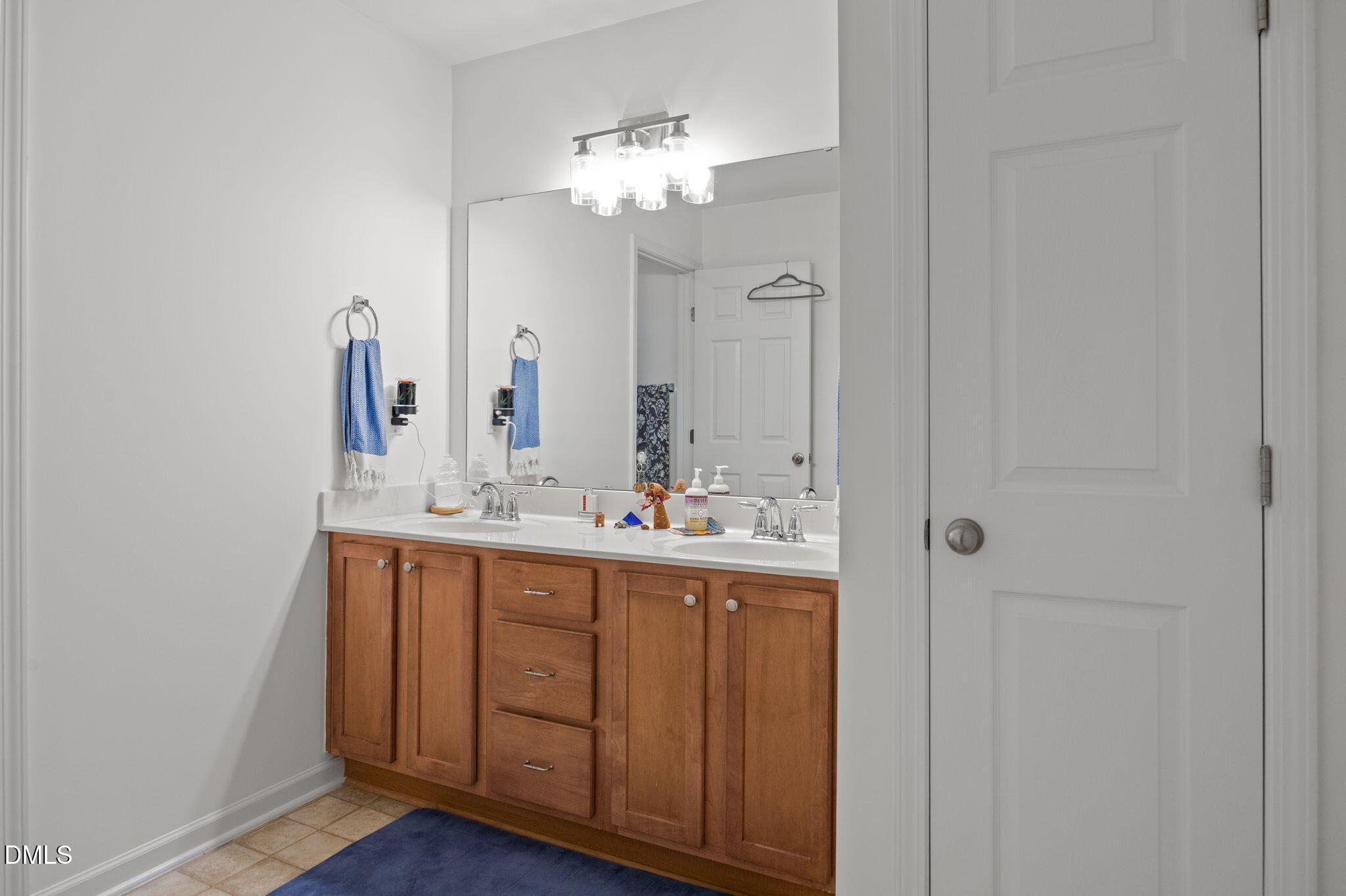1111 Consortium Drive, Unit 109 Raleigh, NC 27603 - Photo 17 of 30 a bathroom with a double vanity sink and a mirror