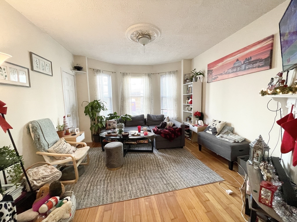 20 Howell Street, Unit 1 Boston, MA 02125 - Photo 3 of 10 a living room with furniture and a wooden floor