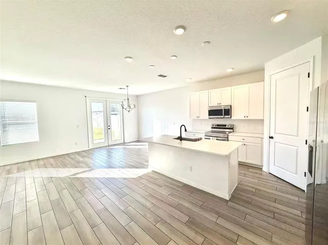 a view of kitchen with wooden floor and electronic appliances