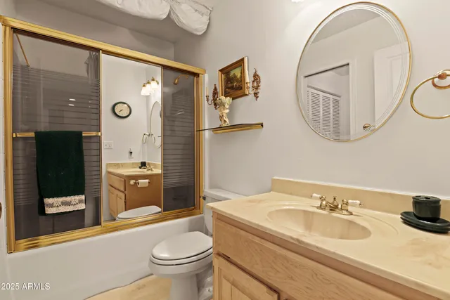 a bathroom with a granite countertop sink a toilet and a mirror