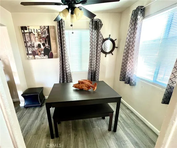 a large kitchen with a stove a refrigerator a sink dishwasher and white cabinets with wooden floor