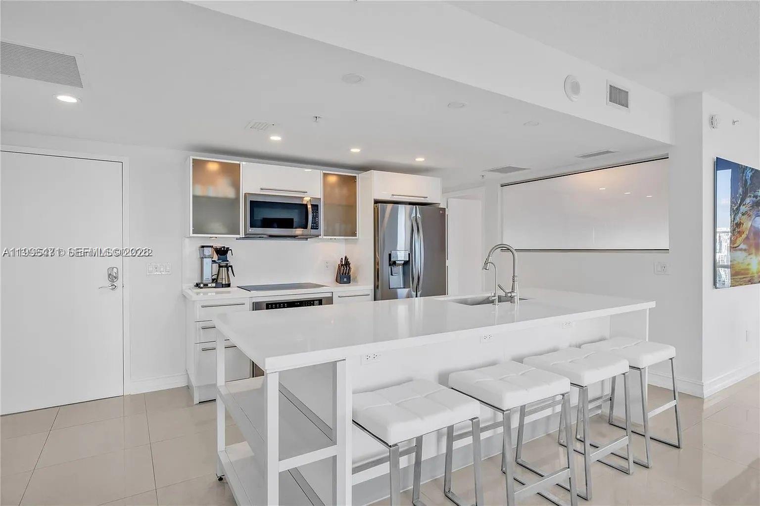 185 Southwest 7th Street, Unit 3611 Miami, FL 33130 - Photo 5 of 14 a kitchen with stainless steel appliances kitchen island granite countertop a table and chairs