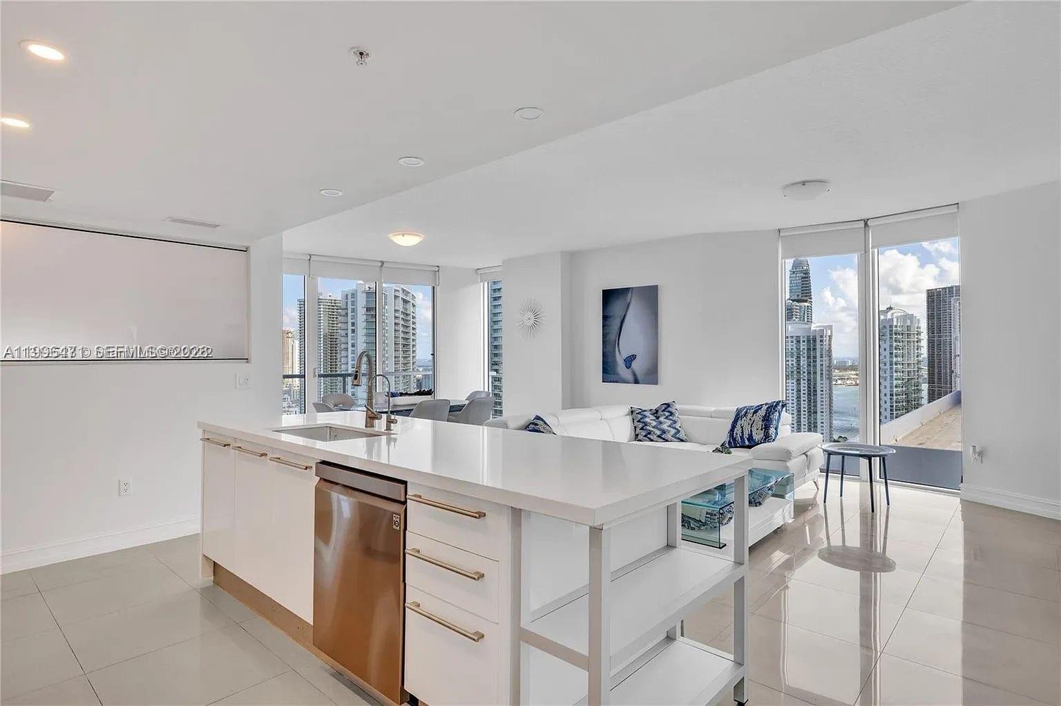 185 Southwest 7th Street, Unit 3611 Miami, FL 33130 - Photo 6 of 14 a large white kitchen with a sink and cabinets