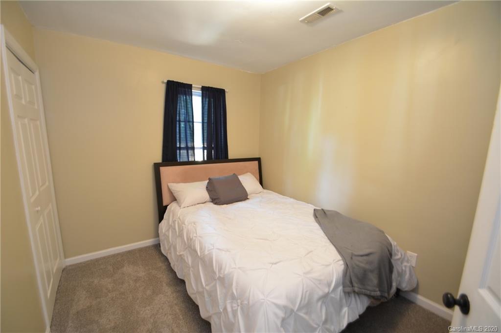 324 Radio Road, Unit 4 Charlotte, NC 28216 - Photo 12 of 19 a large bed in a bedroom next to a small yard