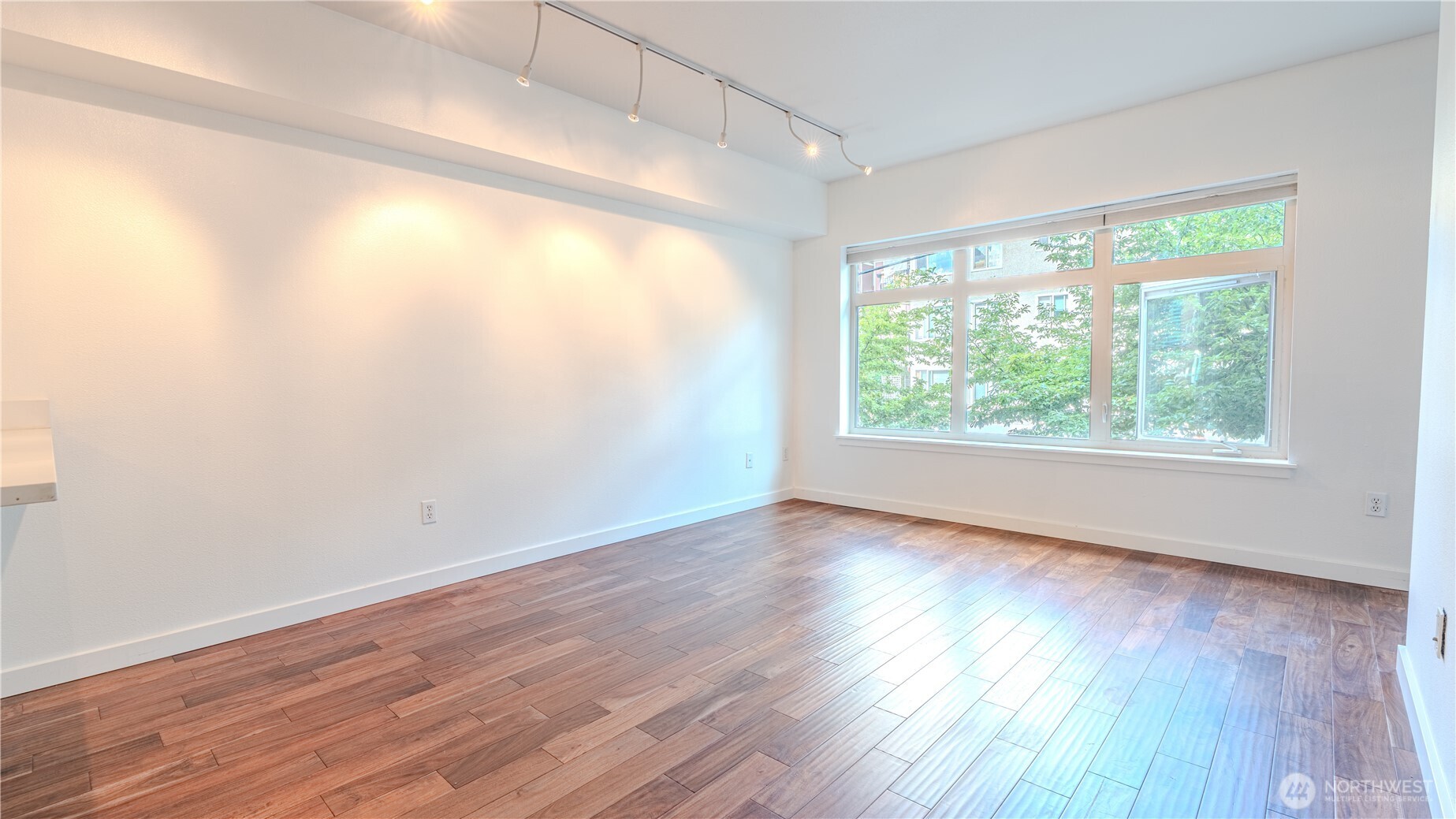 1620 Belmont Avenue, Unit 226 Seattle, WA 98122 - Photo 2 of 19 an empty room with wooden floor and windows