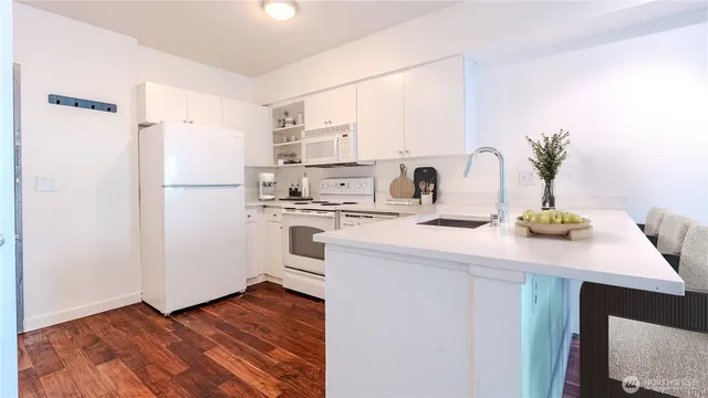 a kitchen with a refrigerator sink and white cabinets