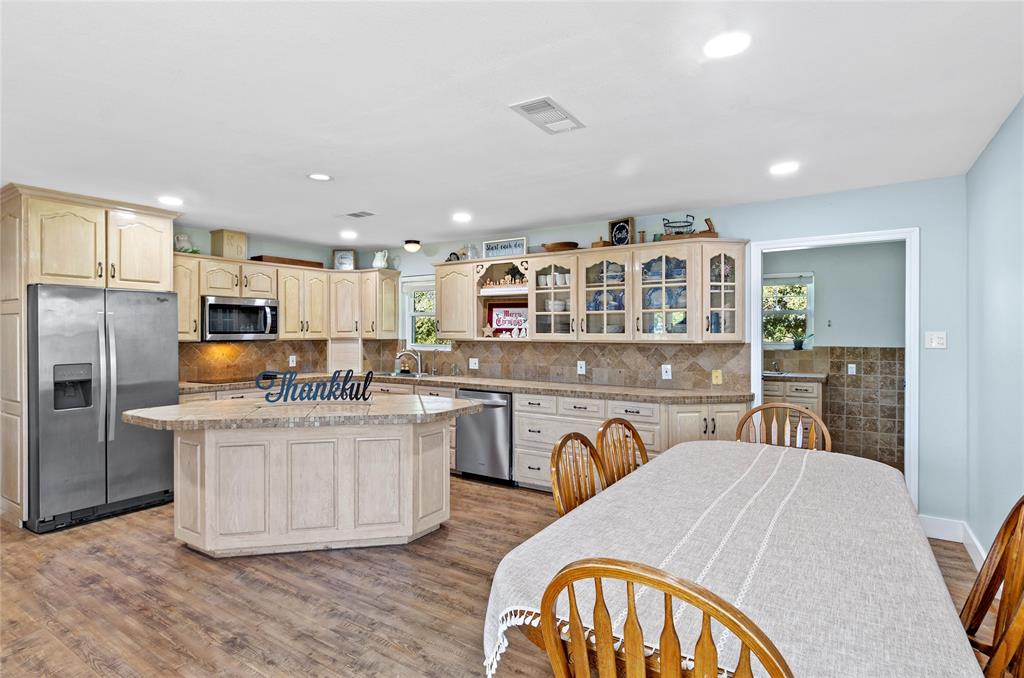 14728 Songbird Lane Haslet, TX 76052 - Photo 9 of 40 a kitchen with stainless steel appliances granite countertop a kitchen island a stove a sink a refrigerator white cabinets and couches