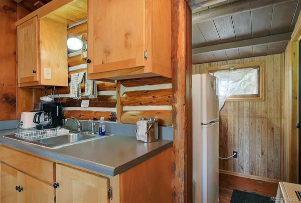 a kitchen with sink a refrigerator and cabinets
