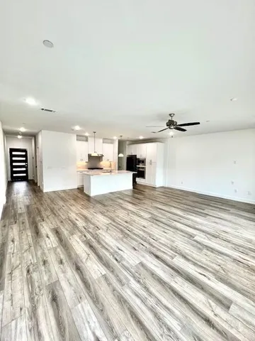 a view of empty room with wooden floor