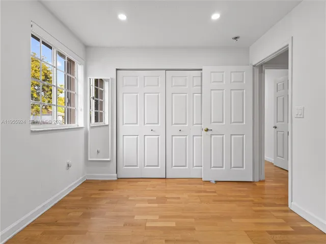a view of an empty room with window and stairs