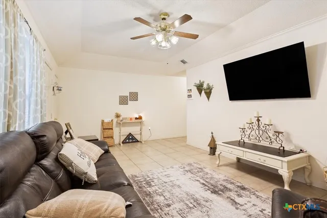a living room with furniture ceiling fan and a flat screen tv