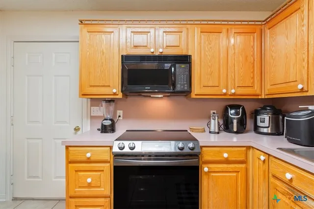 a kitchen with stainless steel appliances granite countertop a stove and a microwave