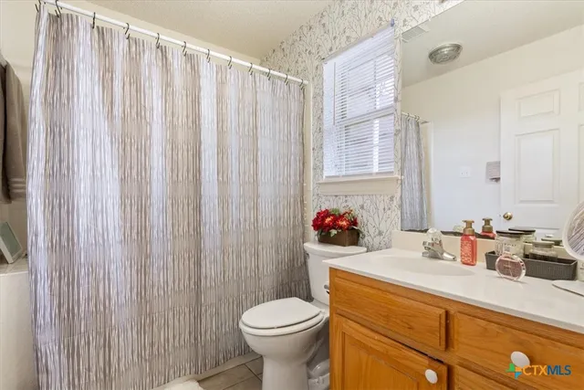 a bathroom with a sink toilet and window