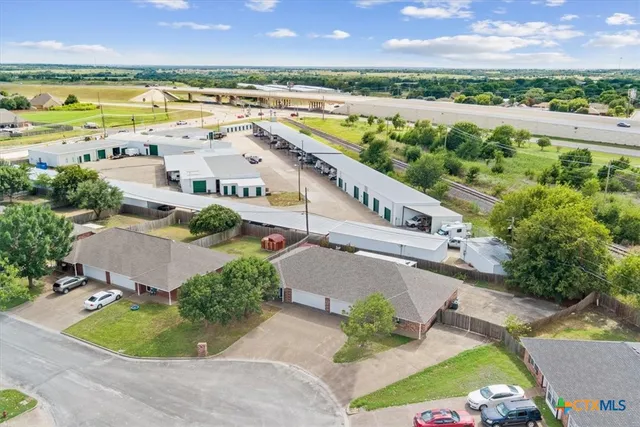 an aerial view of residential houses with outdoor space and ocean view
