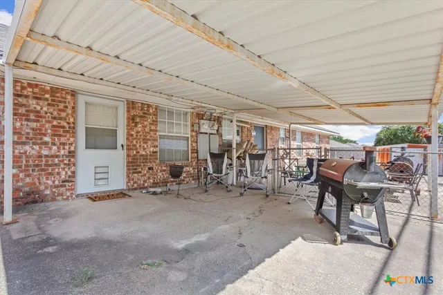 a view of a patio with table and chairs
