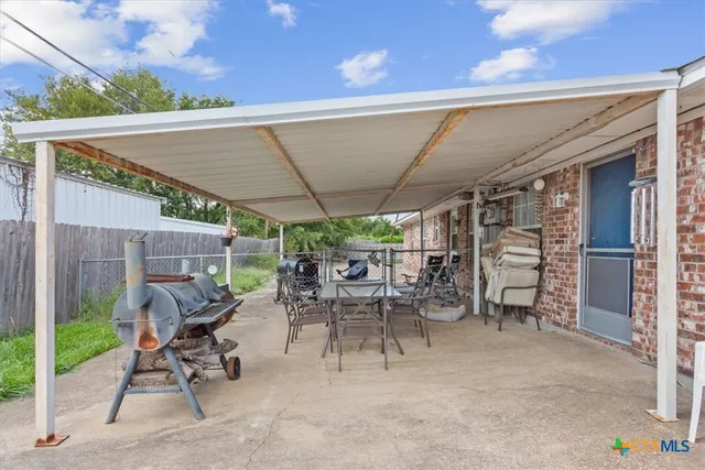 a view of a patio with table and chairs potted plants and a palm tree