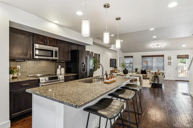 a kitchen with sink refrigerator and microwave