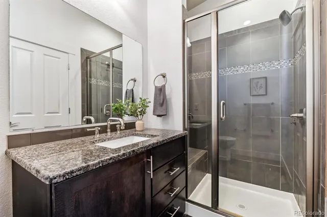 a bathroom with a granite countertop sink and a mirror