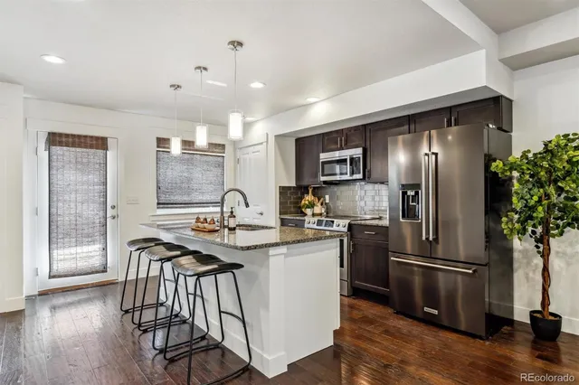 a kitchen with kitchen island a counter top space stainless steel appliances and wooden floor