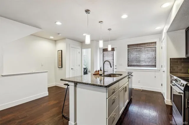 a kitchen with stainless steel appliances a sink a stove a refrigerator and cabinets