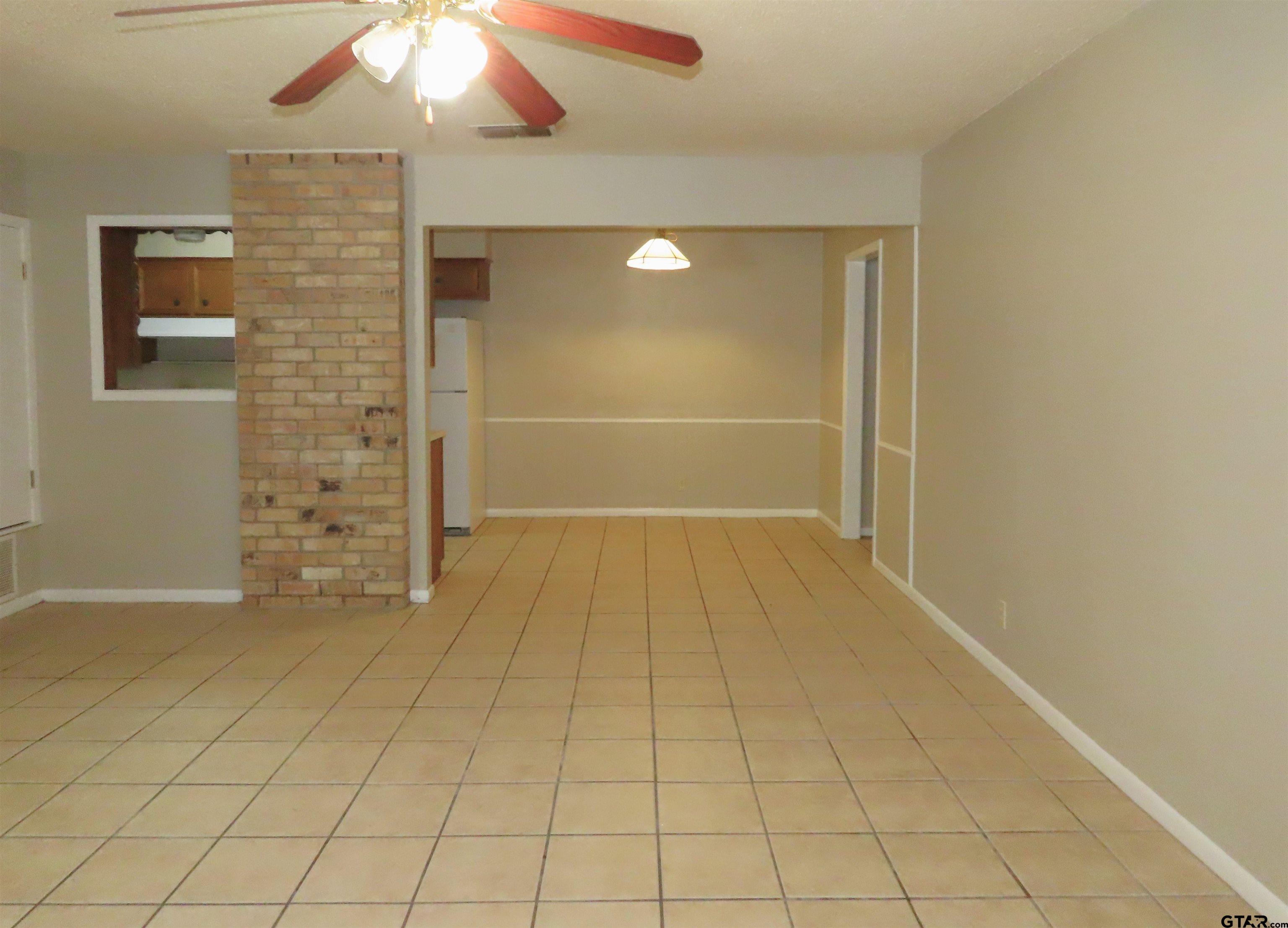 402 Muller Garden Road Tyler, TX 75703 - Photo 7 of 33 en empty room with window and chandelier fan