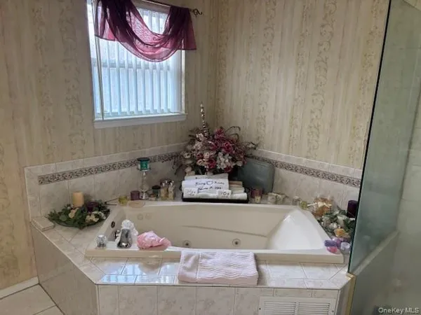 a bathroom with a tub sink and mirror