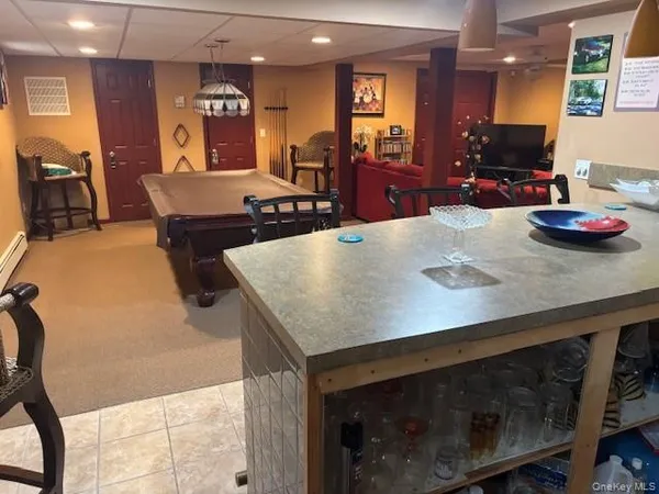 a living room with furniture a flat screen tv and kitchen view