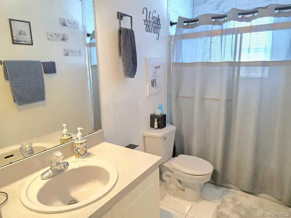 a bathroom with a sink a toilet and shower curtain