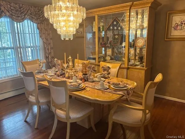 a dining room with furniture a chandelier and wooden floor