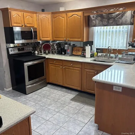 a kitchen with a sink a stove and a microwave